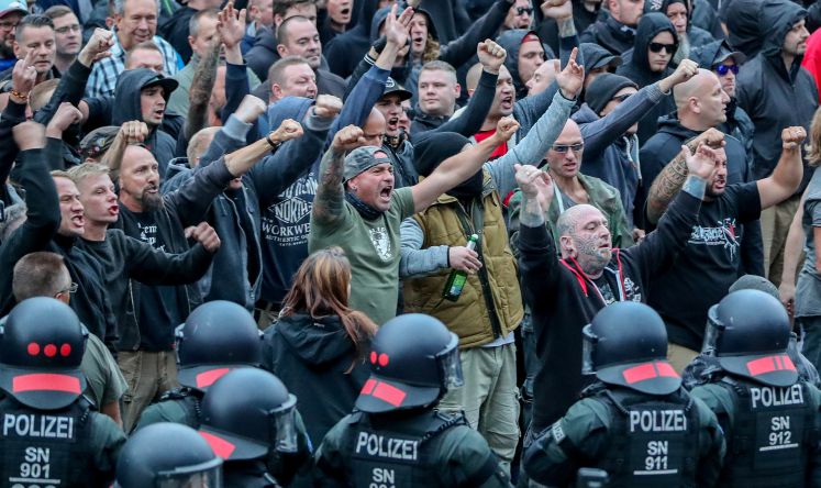 27.08.2018, Sachsen, Chemnitz: Demonstranten aus der rechten Szene gestikulieren und drohen Gegendemonstranten Gewalt an. Nach einem Streit war in der Innenstadt von Chemnitz ein Mann erstochen worden. Die Tat war Anlass für spontane Demonstrationen, bei denen es zu Gewaltausbrüchen kam.