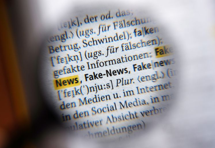 Durch eine Lupe ist der Begriff "Fake-News" für Falschnachrichten am 04.08.2017 in Berlin im neuen Duden zu sehen. Das Nachschlagewerk wurde um 5000 Wörter ergänzt und umfasst nun 145.000 Stichwörter.