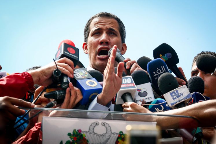 Juan Guaidó beantwortet Fragen in eine Schar von Mikrofonen