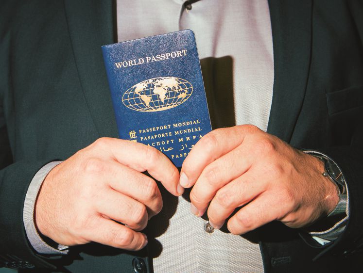 Nahaufnahme von Andreas Bummels Händen, die seinen „Weltausweis“ von der World Service Authority halten