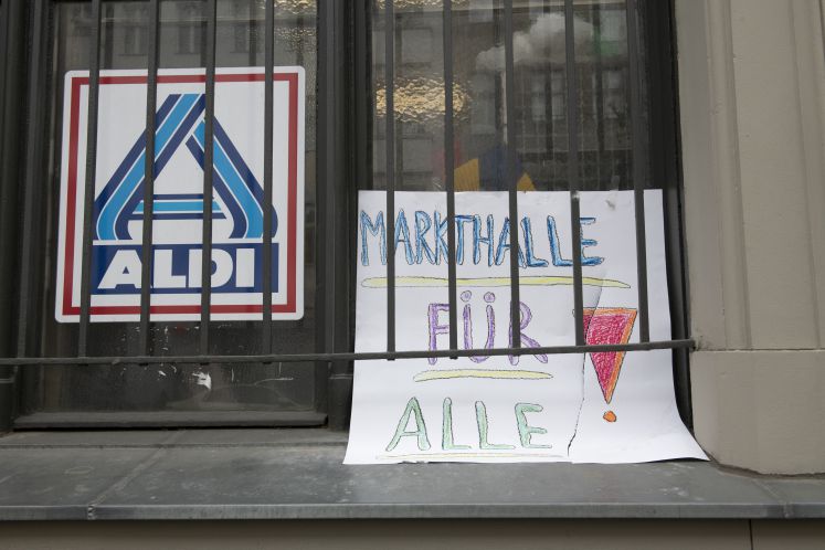 1.04.2019, Berlin: Ein selbstgemaltes Schild mit der Aufschrift «Markthalle für Alle!» ist an einem Fenster neben einem Aldi-Logo angebracht. Der Aldi in der Markthalle Neun in Kreuzberg soll weichen. Die Anwohner setzen sich unerwartet für seinen Verbleib ein.