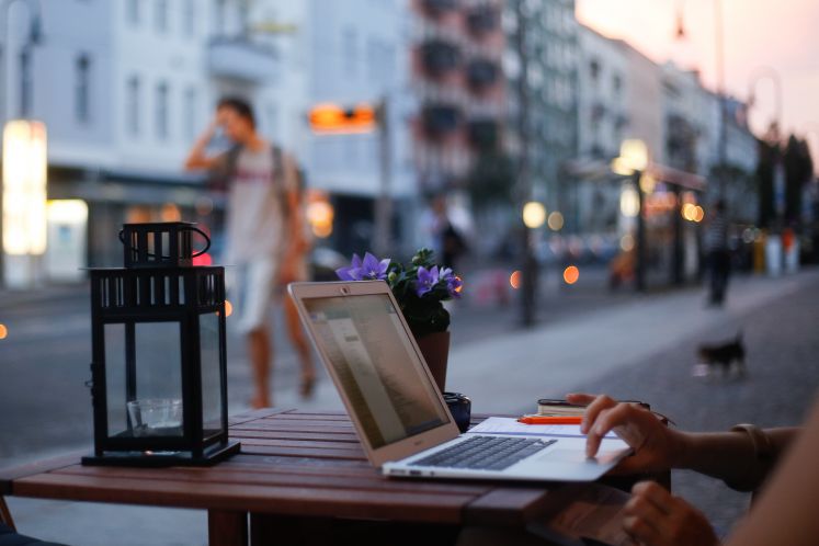Eine Frau arbeitet an einem Laptop in einem Cafe in Prenzlauer Berg in der Danziger Straße.