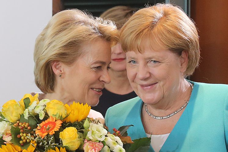 Bundeskanzlerin Angela Merkel (CDU, r) überreicht der scheidenden Verteidigungsministerin Ursula von der Leyen (CDU) an ihrem letzten Kabinettstag einen Blumenstrauß. 
