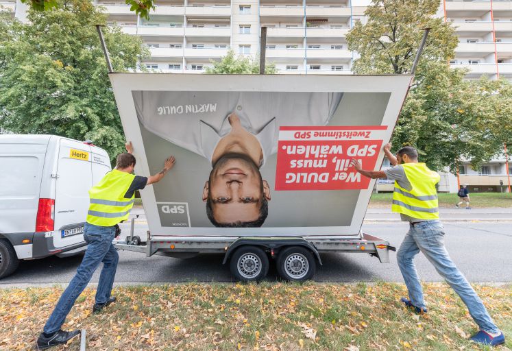02.09.2019, Sachsen, Dresden: Arbeiter laden nach der Landtagswahl ein SPD Wahlplakat mit dem Foto von Martin Dulig, Spitzenkandidat der SPD, auf einen Anhänger.
