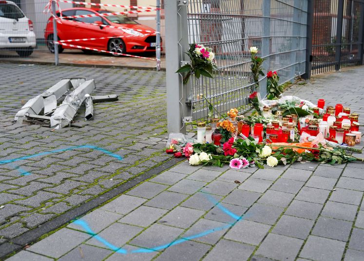 27.10.2019, Hessen, Limburg An Der Lahn: Blumen und Kerzen liegen an der Stelle, an der eine 31-jährige Frau am Freitag getötet wurde. Nach bisherigen Ermittlungen der Polizei hatte ein 34-jähriger Mann seine Ehefrau zunächst mit dem PKW angefahren und die am Boden liegende Frau anschliessend erschlagen.