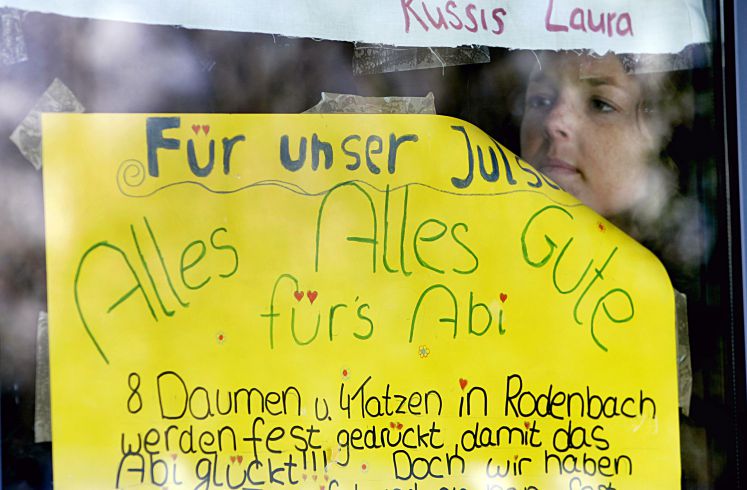 Ein junges Mädchen hängt am Donnerstag (15.03.2007) an der Eingangstür der Wöhlerschule in Frankfurt/Main ein Plakat für ihre Freundin auf, mit dem sie ihr viel Glück für die Abiturprüfungen wünscht. An rund 19 000 hessischen Schulen treten am Freitag Schülerinnen und Schüler zum ersten einheitlichen Landesabitur an.