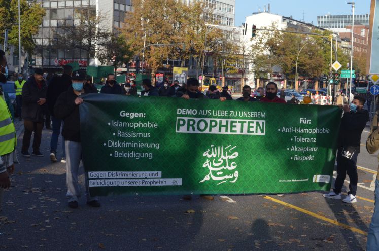 Demonstranten halten Plakat "Aus Liebe zu unserem Propheten" hoch