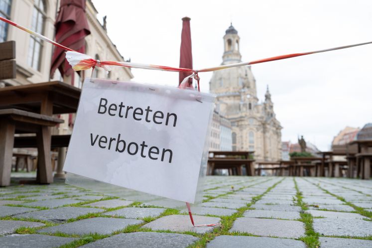 Ein Schild mit der Aufschrift „Betreten verboten“ hängt auf dem Dresdner Neumarkt vor der Frauenkirche an einer Terrassenbestuhlung vor einem geschlossenen Restaurant.