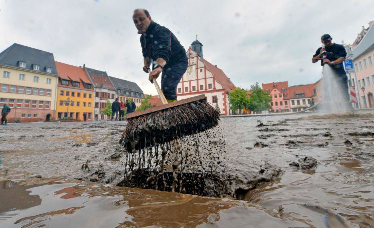 Ein Mann hilft bei den Aufräumarbeiten im Stadtzentrum von Grimma