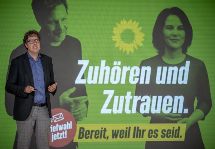 Michael Kellner (Grüne) vor Wahlplakat der Grünen