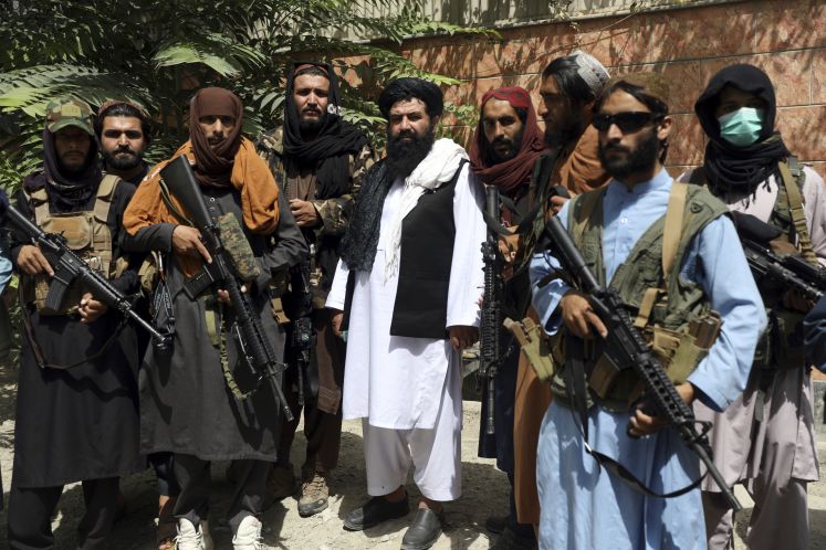 Taliban-Kämpfer stehen zusammen / dpa