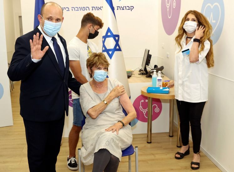 Naftali Bennett (l), Ministerpräsident von Israel, und seine Mutter Mirna Bennett (M) bei einem Impftermin