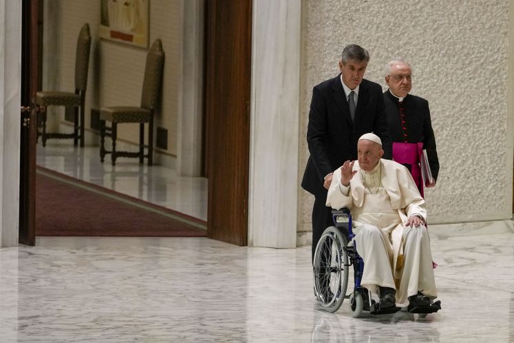 Papst Franziskus im Rollstuhl, winkend