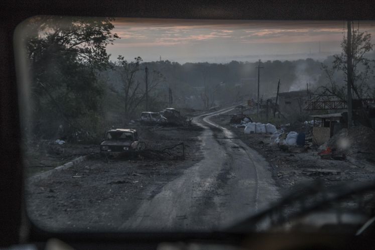 Während schwerer Kämpfe an der Front in Sjewjerodonezk in der Region Luhansk liegen ausgebrannte Autowracks am Rand eines Wegs
