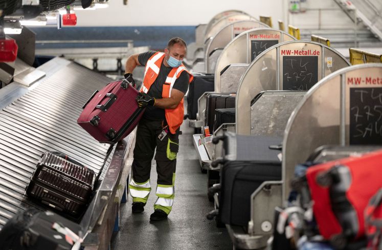 Flughafenmitarbeiter am Gepäckverteiler
