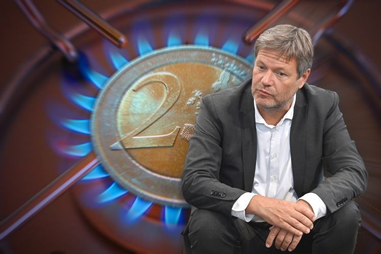 Robert Habeck sitzt vor dem Symbol einer 2 Euro Muenze, die auf einer Gasflamme zu liegen scheint
