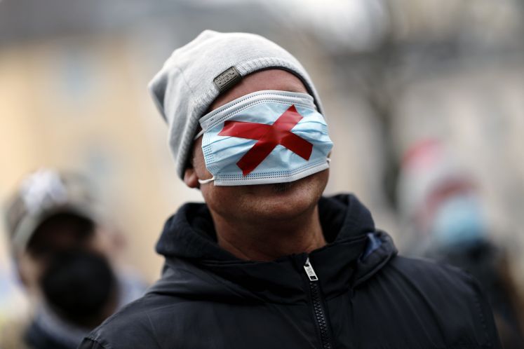 Demonstrant mit OP-Maske auf den Augen