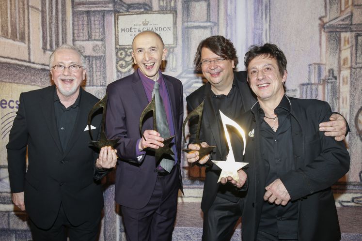 Filmkomponist Éric Serra (ganz rechts) mit dem Preis, den er in Berlin für seinen Beitrag zur internationalen Filmmusik erhalten hat.