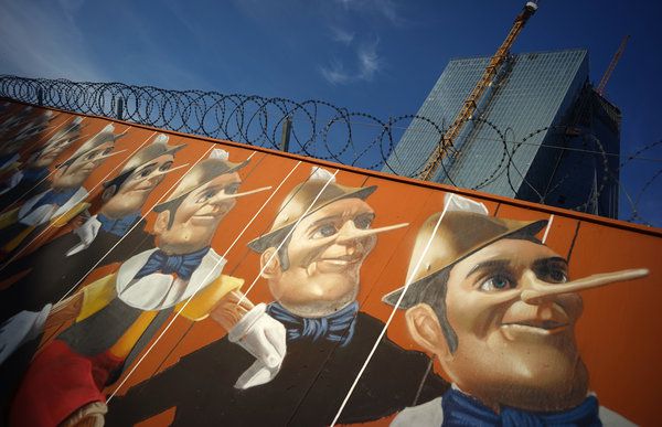 Symbolbild Griechenland-Rettungspolitik: Ein Graffiti mit Pinocchio-Figuren prangt an einem Bauzaun vor der Europäischen Zentralbank (EZB)