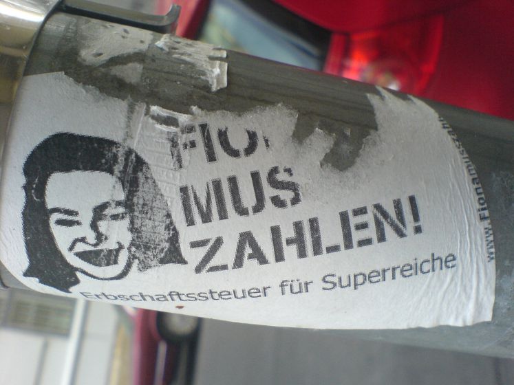 Ein Sticker an einem Laternenpfahl in Wien fordert eine Erbschaftssteuer für Superreiche