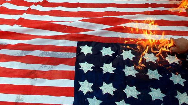 Eine brennende Flagge der USA bei antiamerikanischen Protesten in Palästina