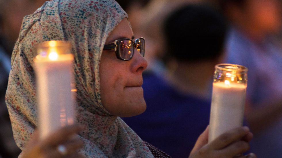 Eine Frau hält eine Kerze für die Opfer des Orlando-Attentats