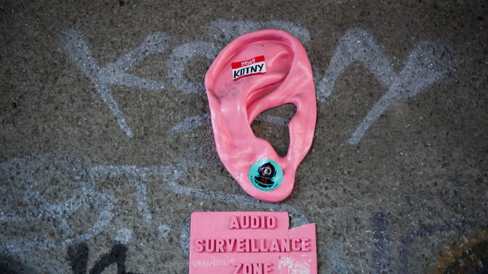 Ein überdimensionales Ohr mit einem Schild auf dem «Audio Surveillance Zone» (Abhörzone) zu lesen ist, hängt an einer Mauer am Alexanderplatz in Berlin