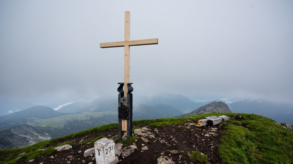 Ein neues Kreuz steht auf dem Gipfel des Schafreiters bei Vorderriss in der Nähe von Lenggries (Bayern) vor den Überresten des zerstörten alten Gipfelkreuzes