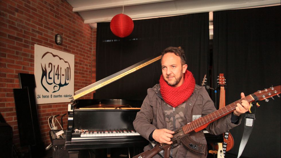 Der Musiker Cesar Lopez spielt auf einer wie ein Gewehr geformten Gitarre 