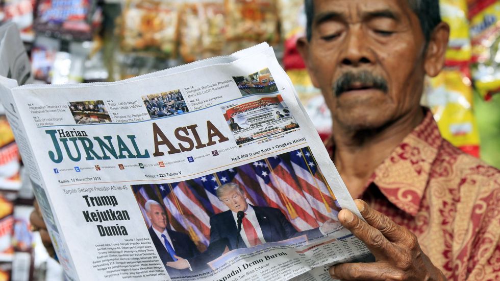 Ein Mann liest eine asiatische Zeitung.