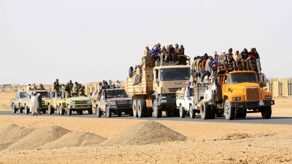 Lastwagen transportieren Flüchtlinge durch eine afrikanische Wüste