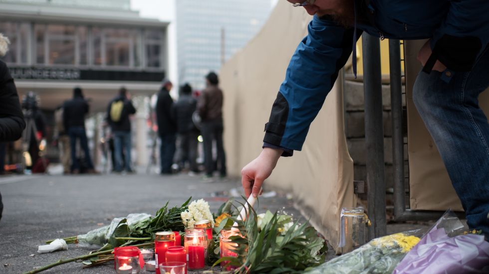 Ein Mann zündet eine Kerze für die Opfer des Berliner Anschlags an