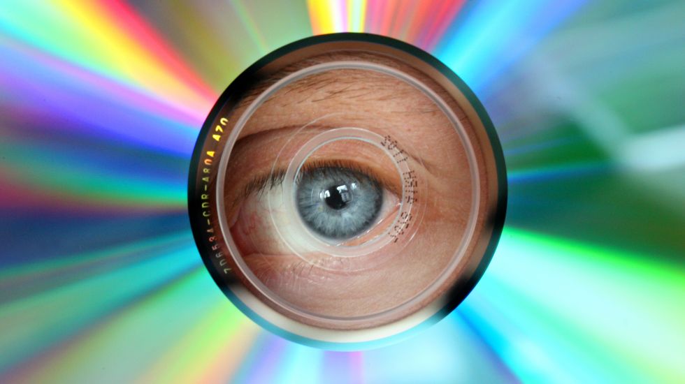 Ein Auge schaut durch das Loch einer CD