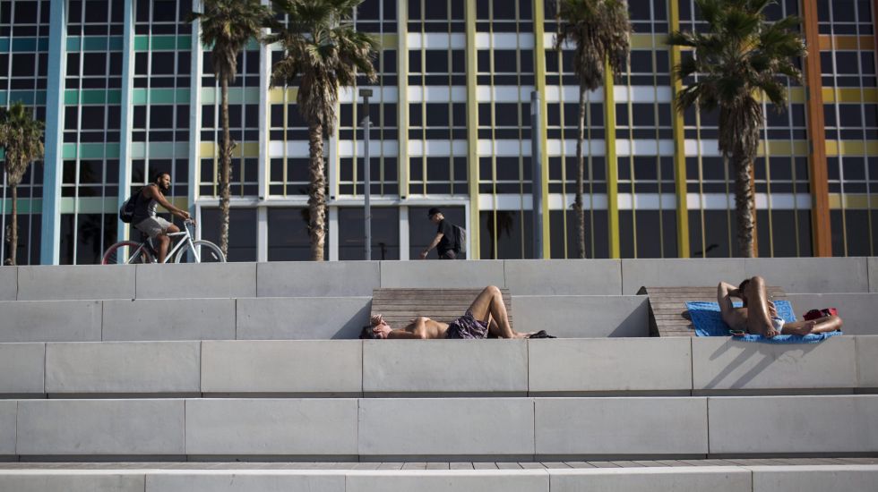 Menschen liegen auf Steintreppenstufen in der Sonne von Tel Aviv