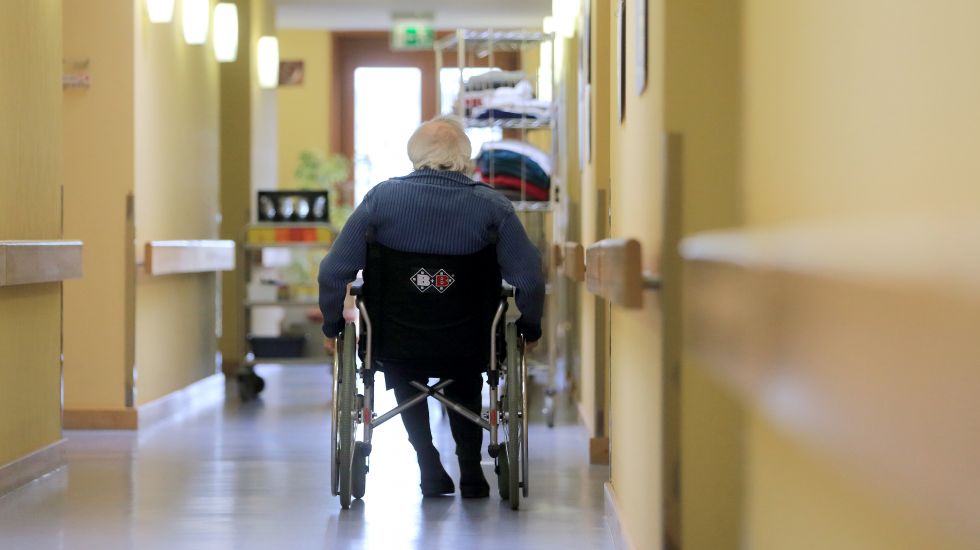 Ein Mann fährt im Rollstuhl über den Gang eines AWO-Seniorenzentrums