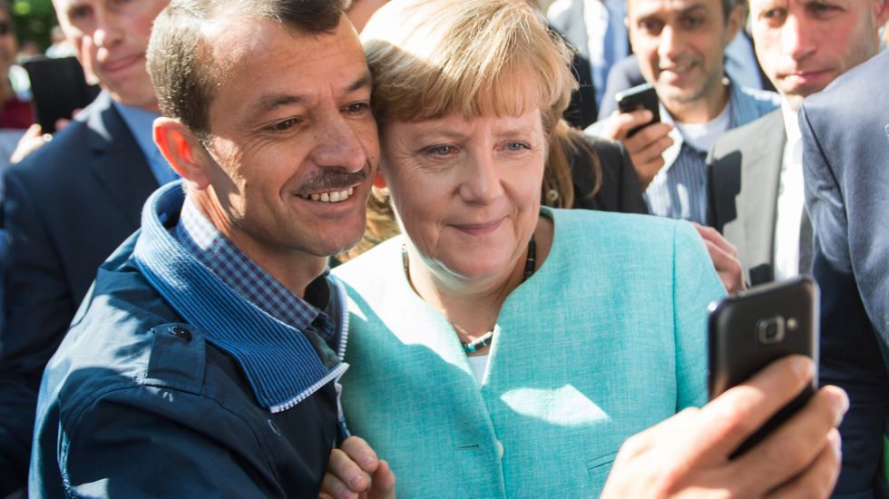 Bundeskanzlerin Angela Merkel (CDU) lässt sich am 10.09.2015 nach dem Besuch einer Erstaufnahmeeinrichtung für Asylbewerber der Arbeiterwohlfahrt (AWO) und der Außenstelle des Bundesamtes für Migration und Flüchtlinge in Berlin-Spandau für ein Selfie zusammen mit einem Flüchtling fotografieren