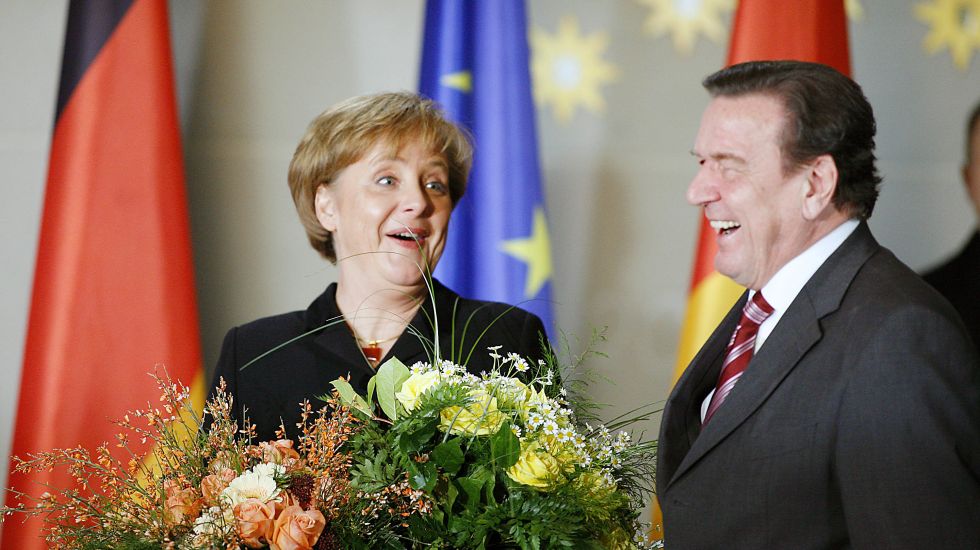 Machtwechsel 2005: Angela Merkel und Gerhard Schröder mit Blumen.