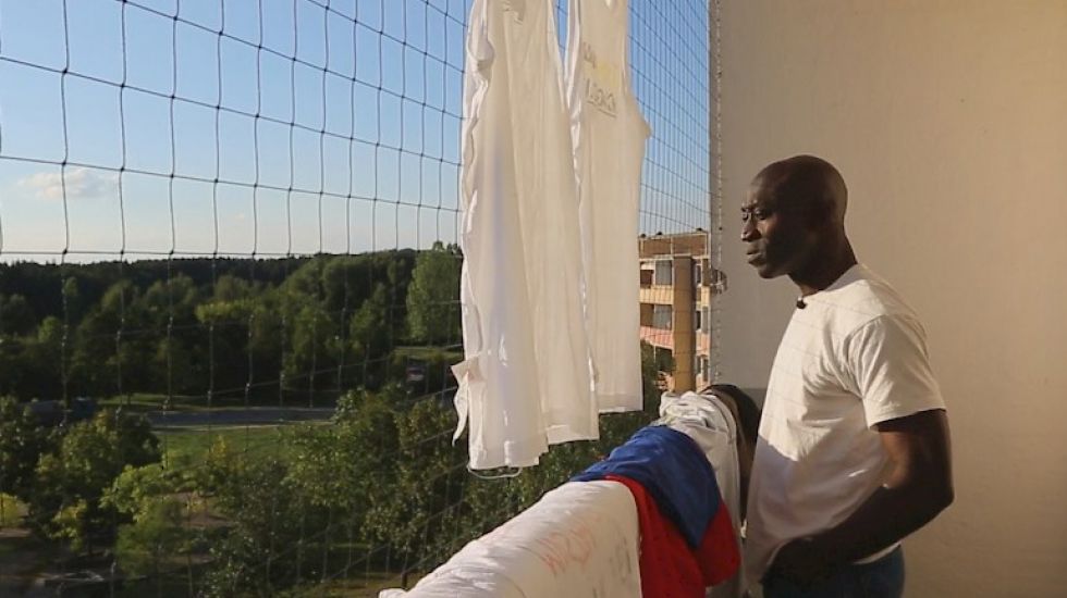 Paul Nkamani steht auf dem Balkon seines Flüchtlingsheims in Eisenhüttenstadt.