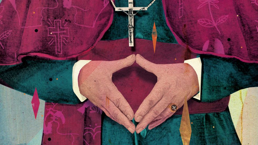 Ein Priester formt unter seiner Kreuzkette mit den Händen die Merkelraute.