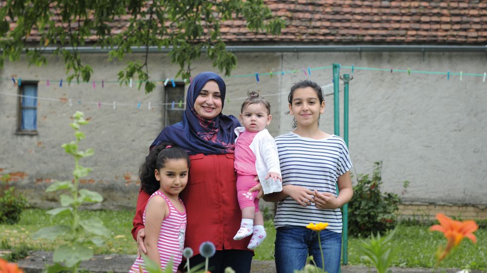 Eine geflüchtete Frau mit ihren drei Töchtern im Garten.