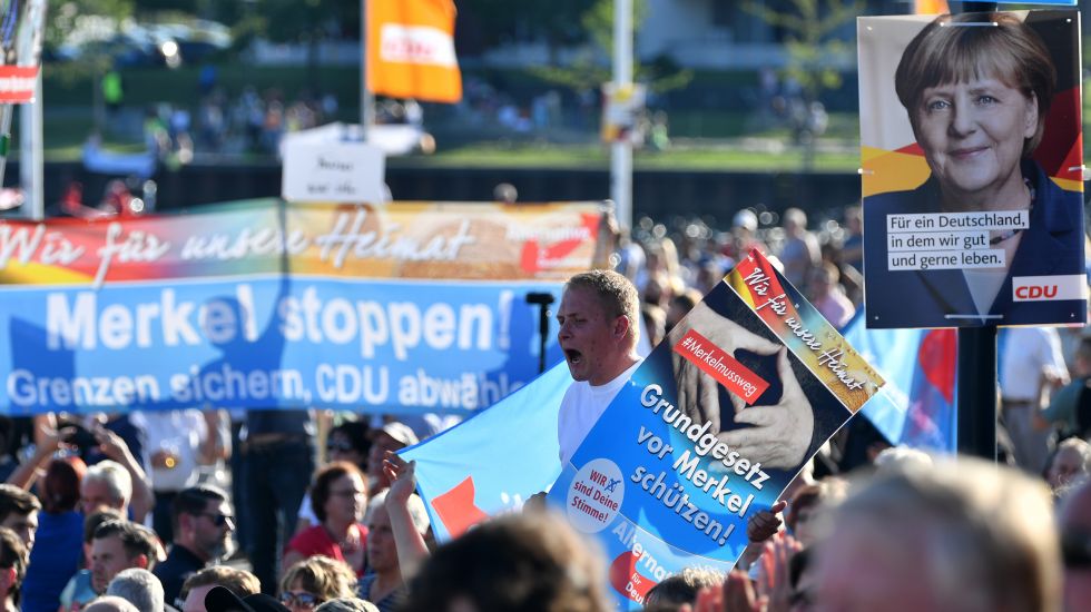 Mitglieder und Sympathisanten der AfD protestieren am 29.08.2017 während eines Wahlkampfauftritts von Bundeskanzlerin Angela Merkel in Bitterfeld-Wolfen (Sachsen-Anhalt).