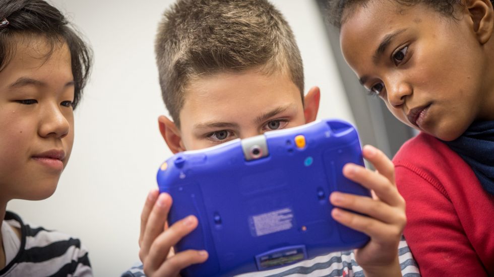 Schüler einer sechsten Klasse begutachten das Lernspiel "Teenage Mutant Ninja Turtles" auf einem "Storio"-Tablet.