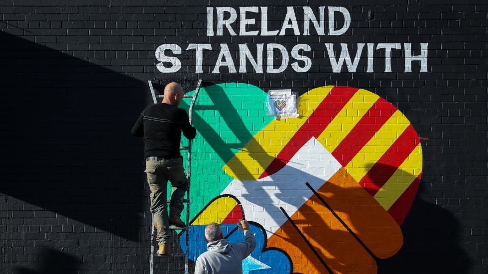 Zwei irisch-republikanische Kunst-Aktivisten malen am 05.10.2017 in Belfast (Großbritanien) auf eine Mauer an der «International Wall/Divis Street» ein Wandbild, das die Unabängigkeitsbewegung im spanischen Katalonien unterstützt.