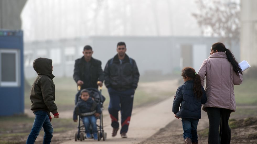 Flüchtlinge und ihre Kinder gehen am 23.11.2016 über das Gelände der Zentralen Ausländerbehörde (ZABH) in Eisenhüttenstadt (Brandenburg)