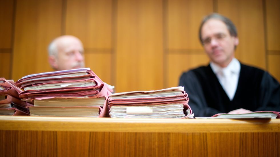 Prozessakten liegen am 18.11.2014 in Bochum (Nordrhein-Westfalen) am Landgericht während eines Strafprozesses in einem Verhandlungssaal vor einem Richter und einem Schöffen