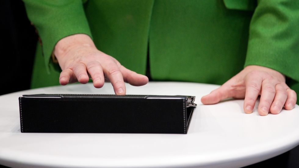 Bundeskanzlerin Angela Merkel (CDU) tippt 2015 in Hannover auf der weltweit größten Computermesse CeBIT auf einem Tablet-Computer.