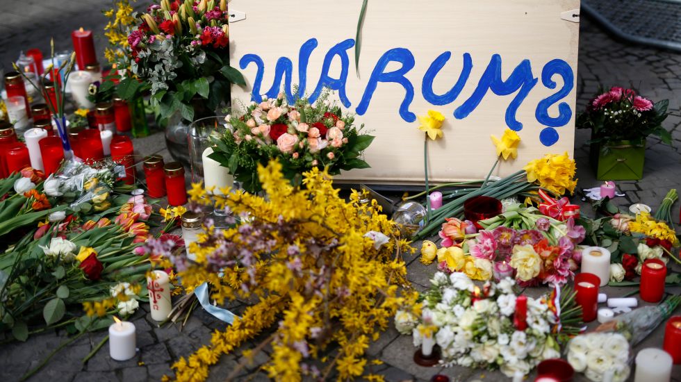 Schild mit der Aufschrift "Warum?", Blumen und Kerzen vor dem Kiepenkerl in Münster