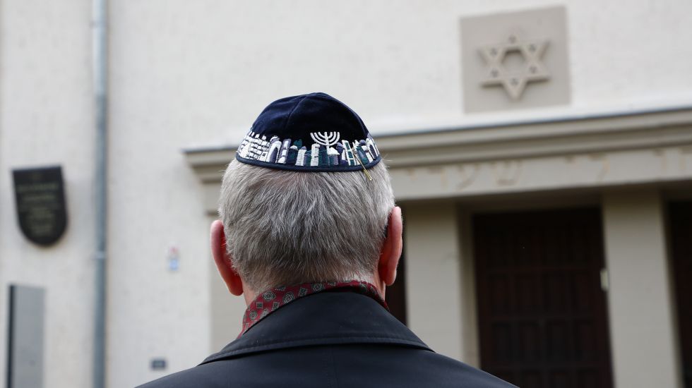 Teilnehmer einer Demonstration mit einer Kippa im Stadtzentrum von Erfurt vor der Neuen Synagoge nehmen Stellung gegen Antisemitismus und Ausgrenzung.