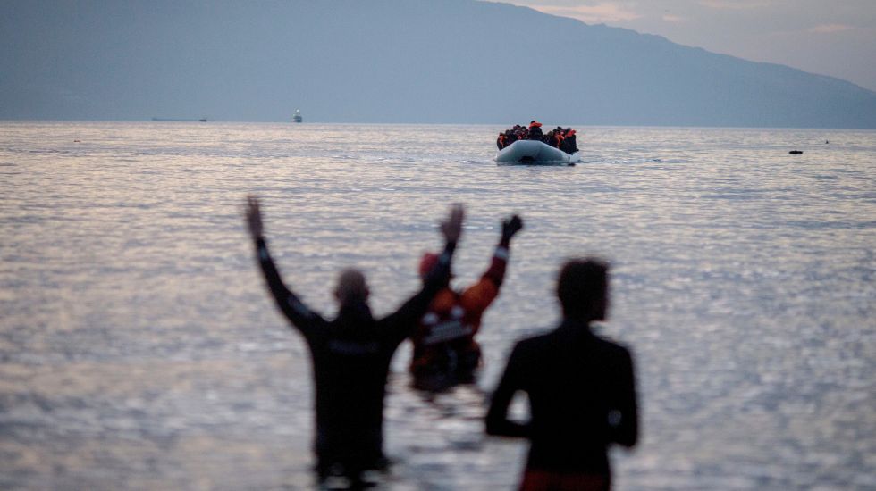 Flüchtlinge kommen am 09.03.2016 in einem Schlauchboot aus der Türkei auf der griechischen Insel Lesbos in der Nähe der Hafenstadt Mitilini (Mytilini) an und werden von Helfern (vorne) erwartet. In der Nacht sind zahlreiche Boote an den Stränden im Süden der Insel angelandet.