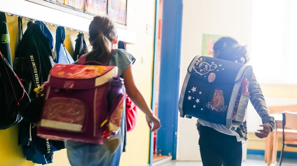 Zwei Schulkinder aus der vierten Klasse einer Grundschule laufen in den Klassenraum